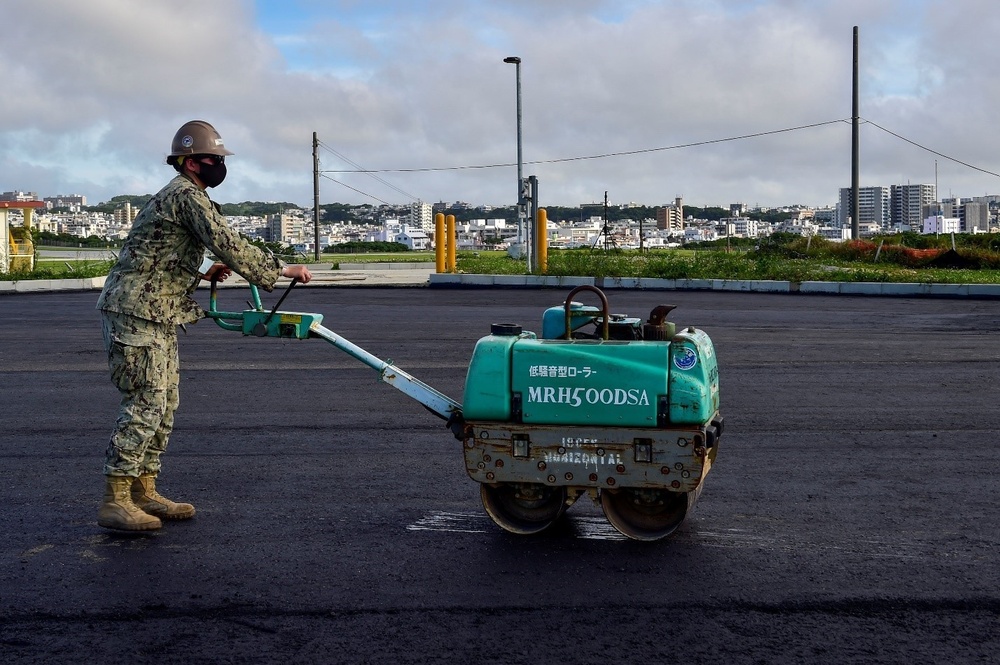 U.S. Navy Seabees with NMCB-5 place asphalt for Marine Air Control Squadron 4