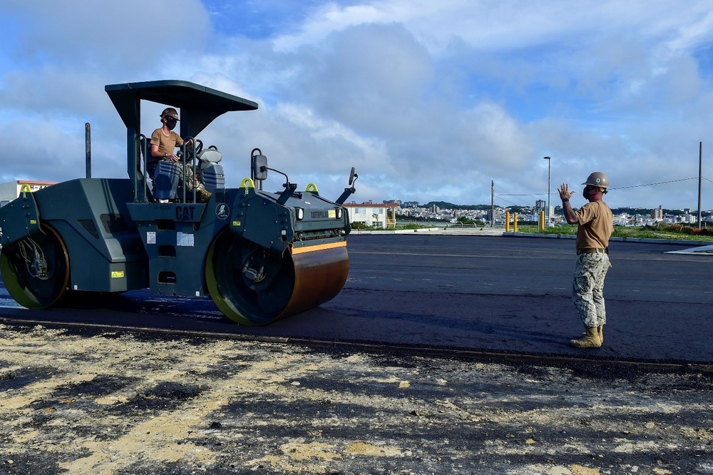 U.S. Navy Seabees with NMCB-5 place asphalt for Marine Air Control Squadron 4
