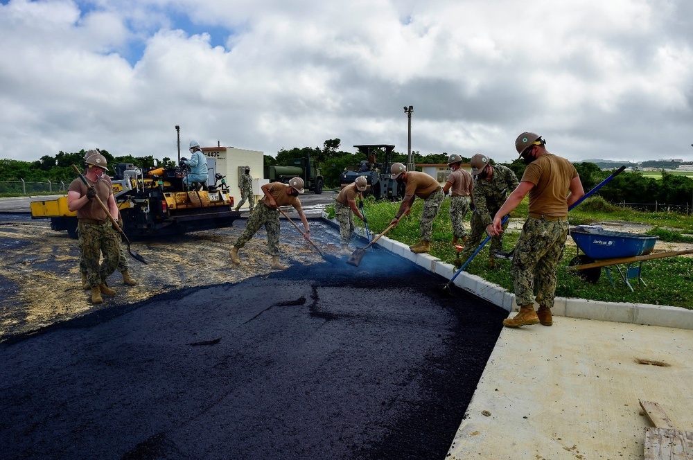 U.S. Navy Seabees with NMCB-5 place asphalt for Marine Air Control Squadron 4