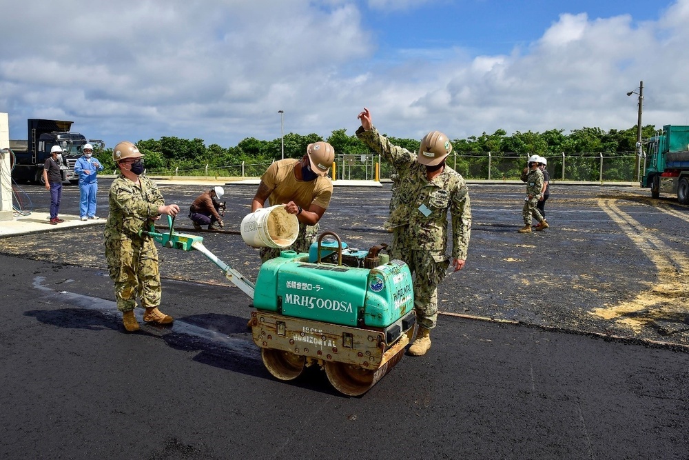 U.S. Navy Seabees with NMCB-5 place asphalt for Marine Air Control Squadron 4