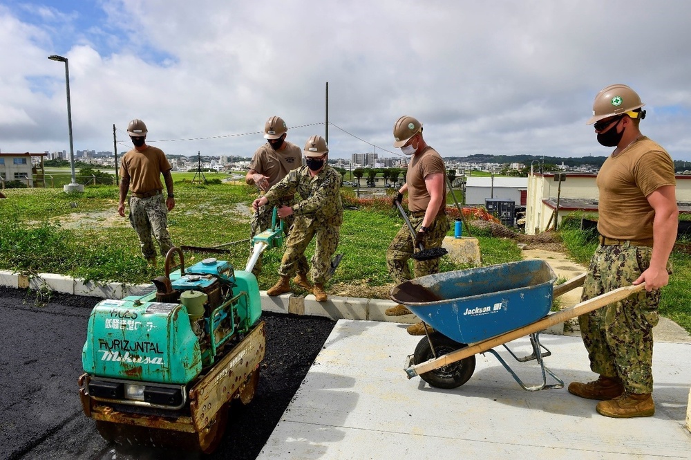 U.S. Navy Seabees with NMCB-5 place asphalt for Marine Air Control Squadron 4