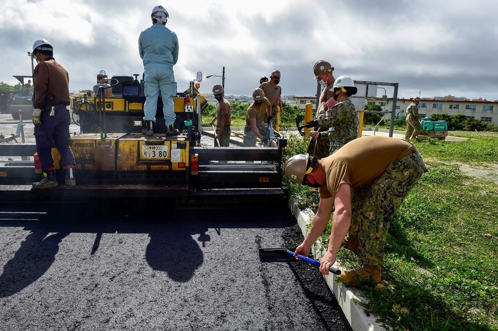 U.S. Navy Seabees with NMCB-5 place asphalt for Marine Air Control Squadron 4