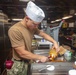 Sailors and Marines work in the galley