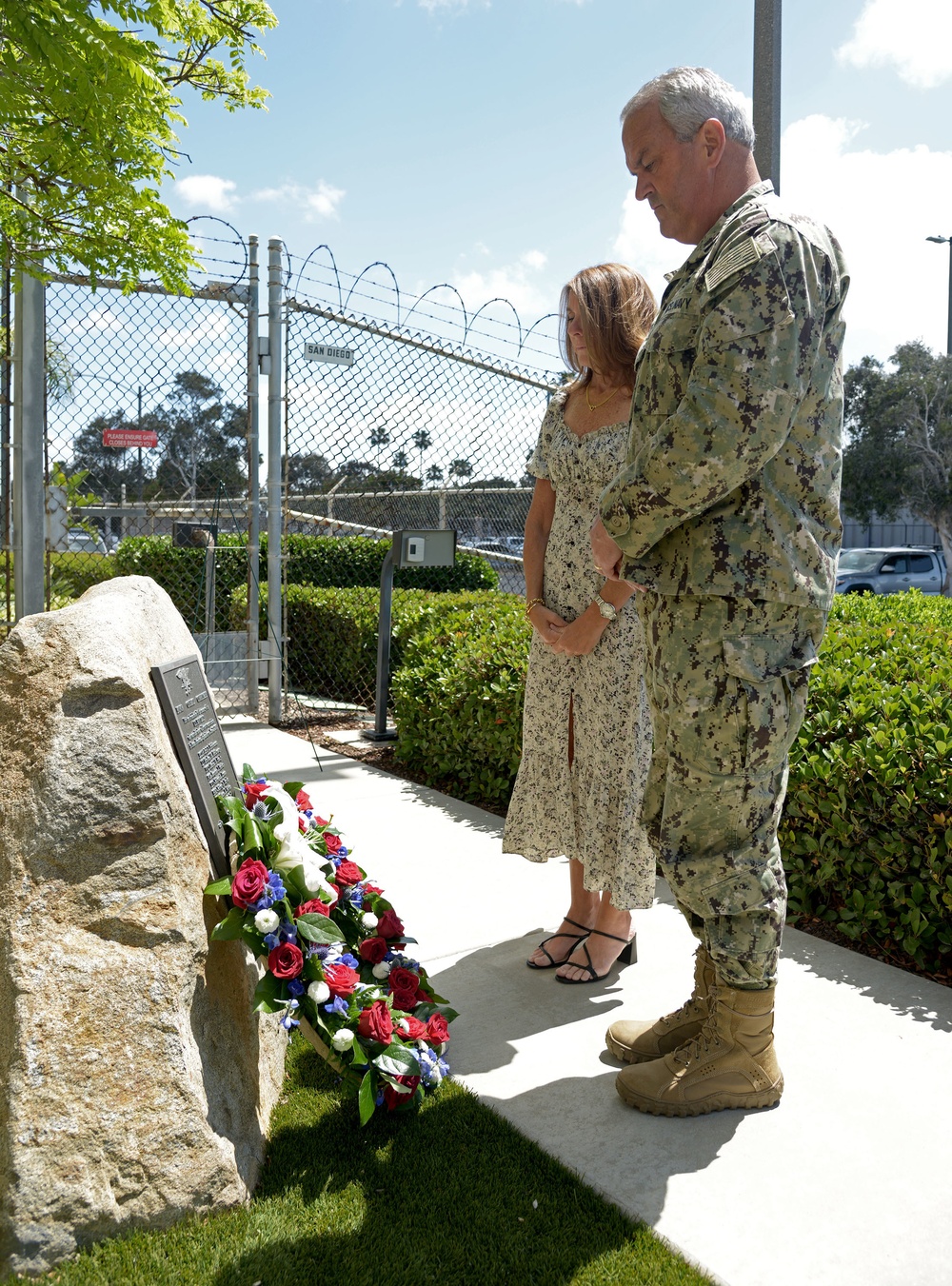 Rear Adm. Collin Green, commander, Naval Special Warfare Command (NSWC) and his wife Alyssa lay a wreath in observance of Memorial Day on the Gold Medallion Tree Memorial at NSWC Headquarters.