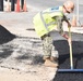 Builder Constructionman 3rd Class Meghan Plunk smooths asphalt in the Navy Exchange parking lot on NSA Souda Bay, Greece