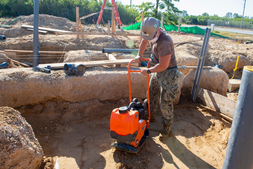 NMCB 1 Seabees install sewage lines for kennel office building project.