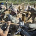 NMCB 1 Seabees fill post holes with concrete during an obstacle course construction project.