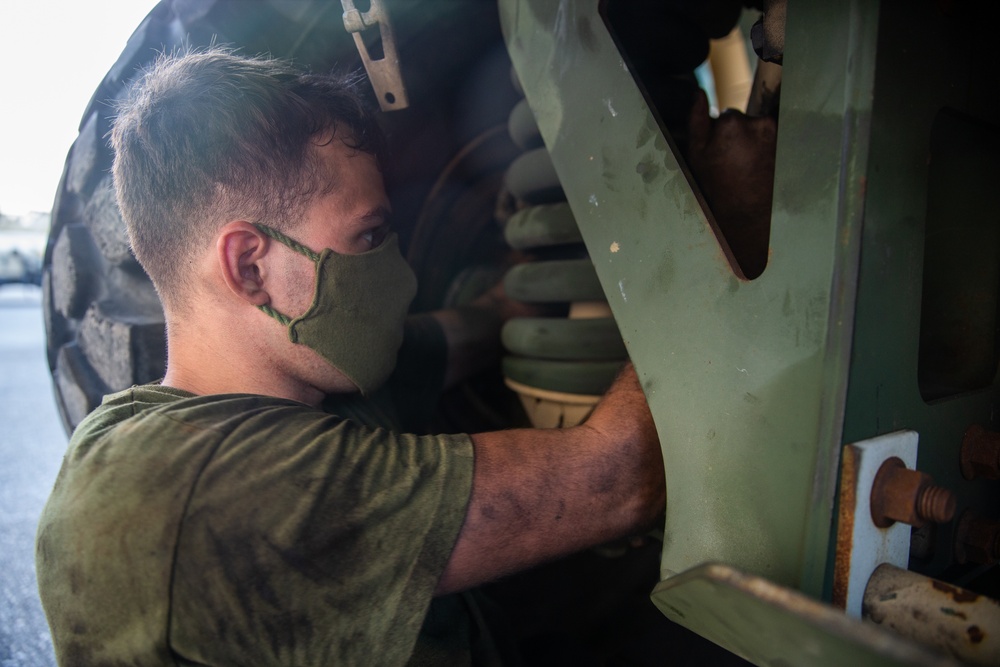 U.S. Marines perform maintenance on a fleet of tactical vehicles
