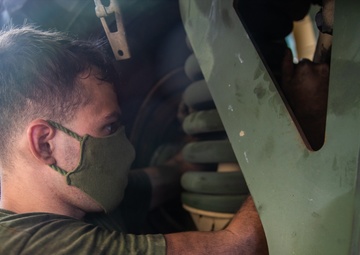 U.S. Marines perform maintenance on a fleet of tactical vehicles