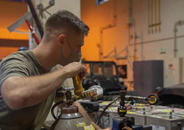 U.S. Marines perform maintenance on a fleet of tactical vehicles
