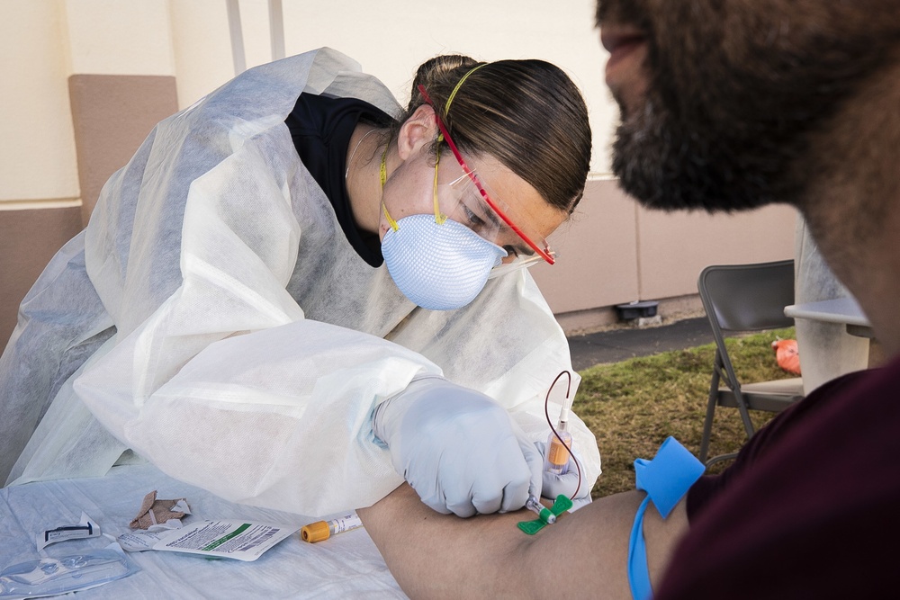 Navy Corpsmen with U.S. Naval Hospital Guam take samples from Sailors attached to USS Theodore Roosevelt for a CDC Study