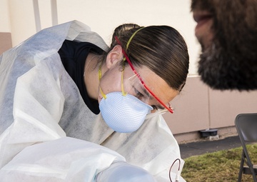 Navy Corpsmen with U.S. Naval Hospital Guam take samples from Sailors attached to USS Theodore Roosevelt for a CDC Study