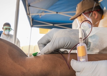 Navy Corpsmen with U.S. Naval Hospital Guam take samples from Sailors attached to USS Theodore Roosevelt for a CDC Study