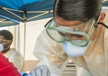 Navy Corpsmen with U.S. Naval Hospital Guam take samples from Sailors attached to USS Theodore Roosevelt for a CDC Study
