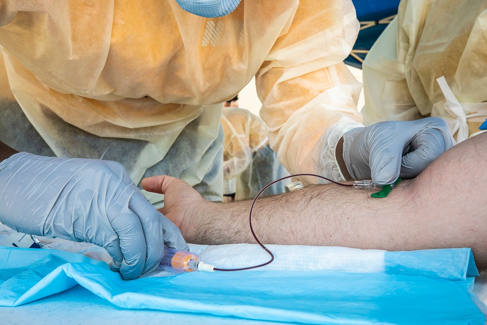 Navy Corpsmen with U.S. Naval Hospital Guam take samples from Sailors attached to USS Theodore Roosevelt for a CDC Study