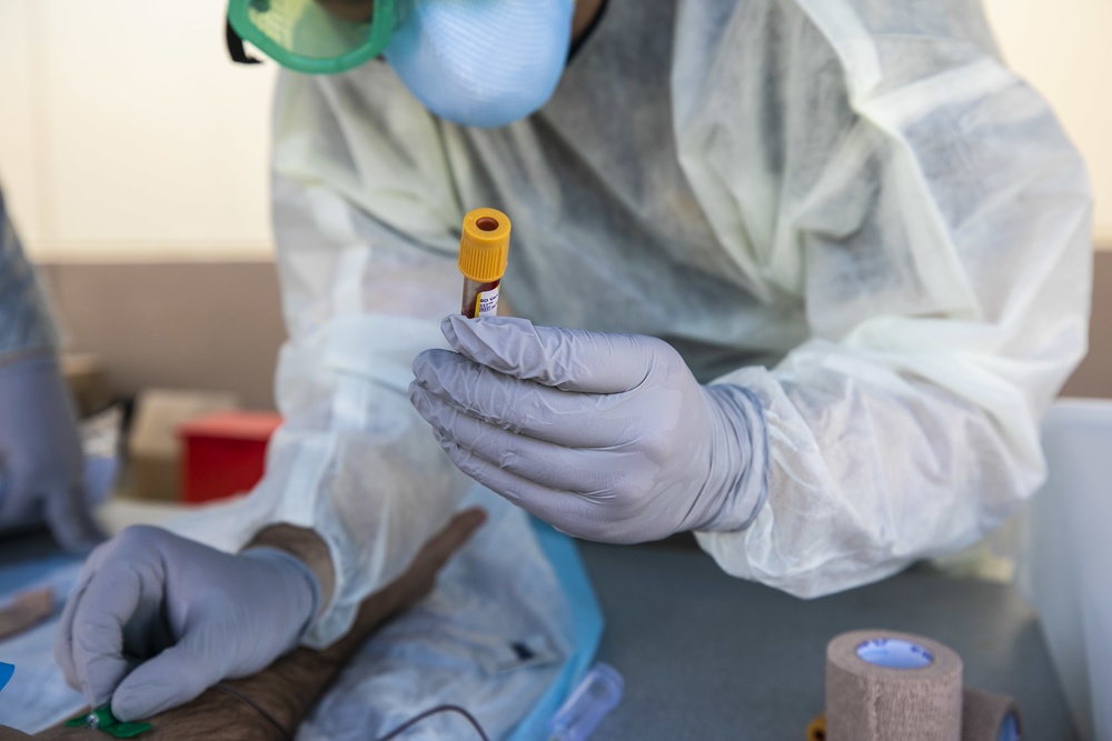 Navy Corpsmen with U.S. Naval Hospital Guam take samples from Sailors attached to USS Theodore Roosevelt for a CDC Study