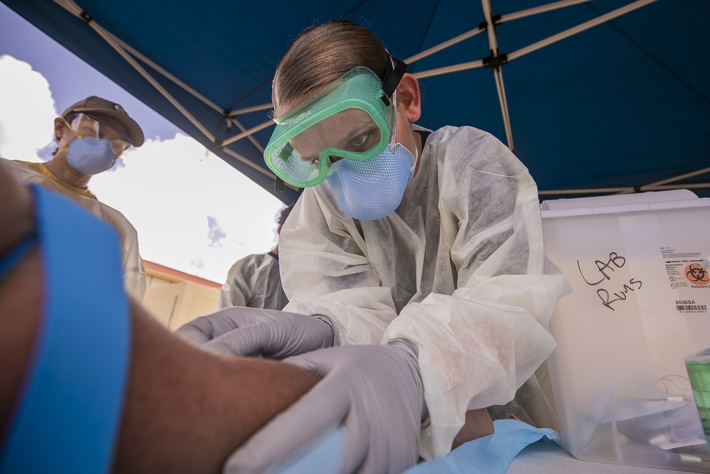 Navy Corpsmen with U.S. Naval Hospital Guam take samples from Sailors attached to USS Theodore Roosevelt for a CDC Study