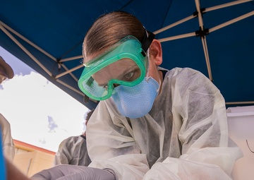 Navy Corpsmen with U.S. Naval Hospital Guam take samples from Sailors attached to USS Theodore Roosevelt for a CDC Study