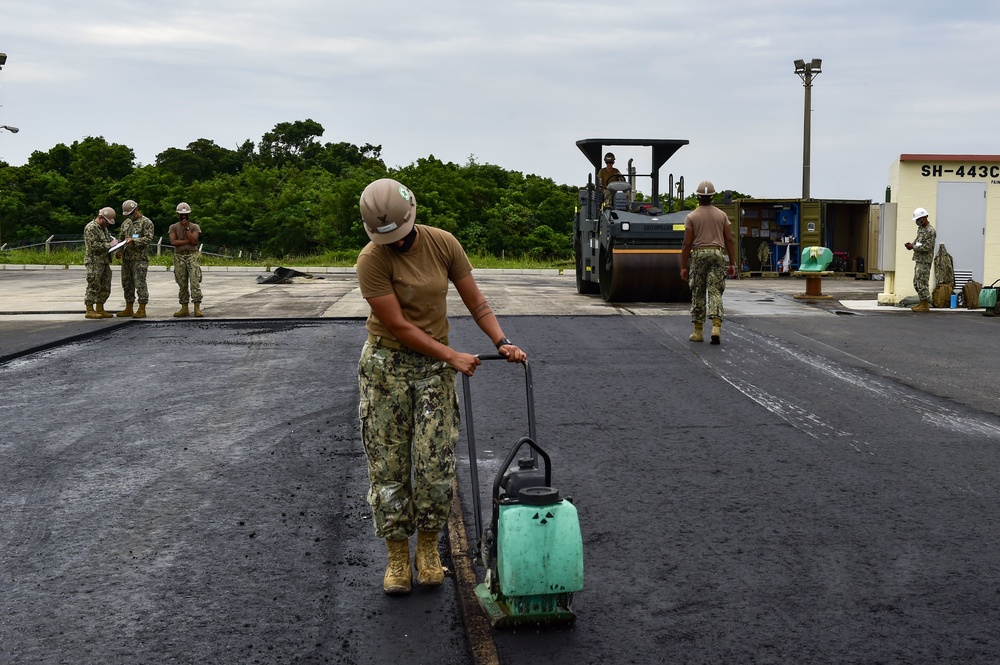 U.S. Navy Seabees with NMCB-5 place asphalt for Marine Air Control Squadron 4