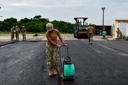 U.S. Navy Seabees with NMCB-5 place asphalt for Marine Air Control Squadron 4