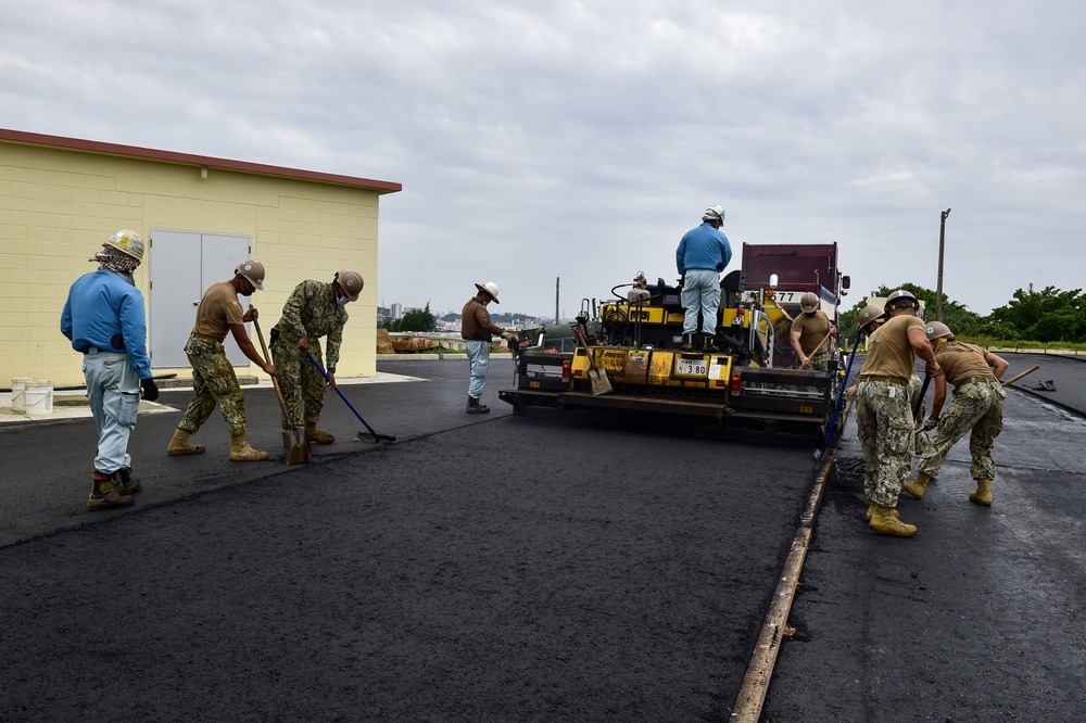 U.S. Navy Seabees with NMCB-5 place asphalt for Marine Air Control Squadron 4