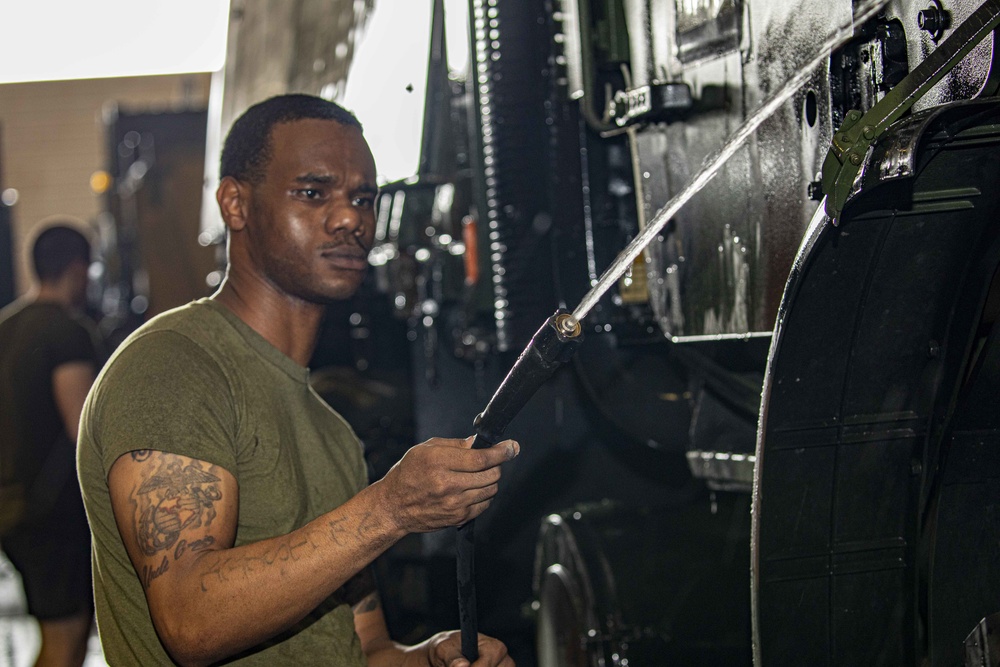 Sailors perform a vehicle wash down