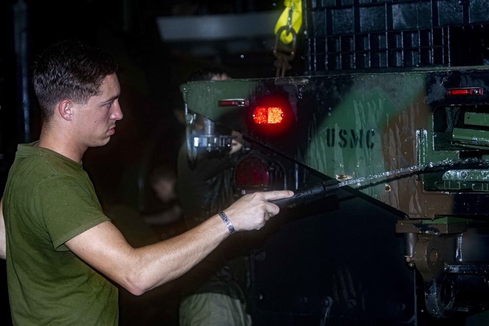 Sailors perform a vehicle wash down