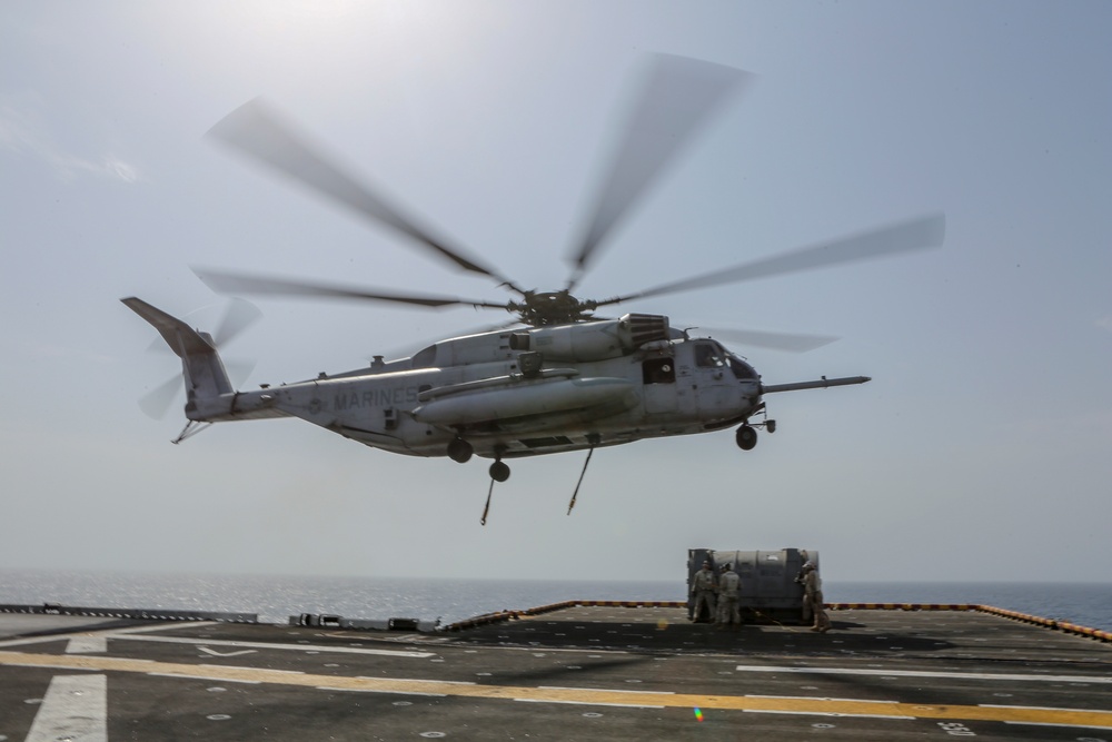 Helicopter support team transports AV-8B Harrier engine from USS Bataan