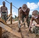 Seabees assigned to Naval Mobile Construction Battalion (NMCB) hammer in stakes to secure a log during an obstacle course construction project on aboard Naval Station Rota, Spain.