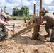 Seabees assigned to Naval Mobile Construction Battalion (NMCB) space and secure a log during an obstacle course construction project on aboard Naval Station Rota, Spain.