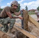 Seabees assigned to Naval Mobile Construction Battalion (NMCB) space and secure a log during an obstacle course construction project on aboard Naval Station Rota, Spain.