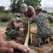 Seabees assigned to Naval Mobile Construction Battalion (NMCB) space and secure a log during an obstacle course construction project on aboard Naval Station Rota, Spain.