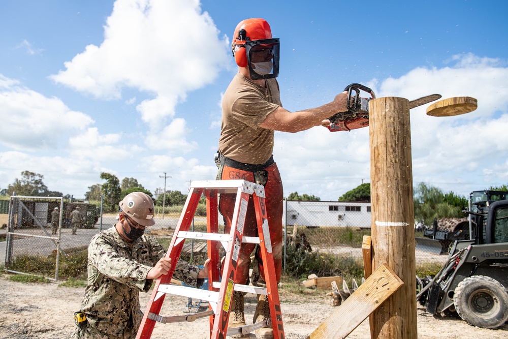 Seabees assigned to Naval Mobile Construction Battalion (NMCB) use a sawzall to level off the top of a log during an obstacle course construction project on aboard Naval Station Rota, Spain.