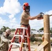 Seabees assigned to Naval Mobile Construction Battalion (NMCB) use a sawzall to level off the top of a log during an obstacle course construction project on aboard Naval Station Rota, Spain.