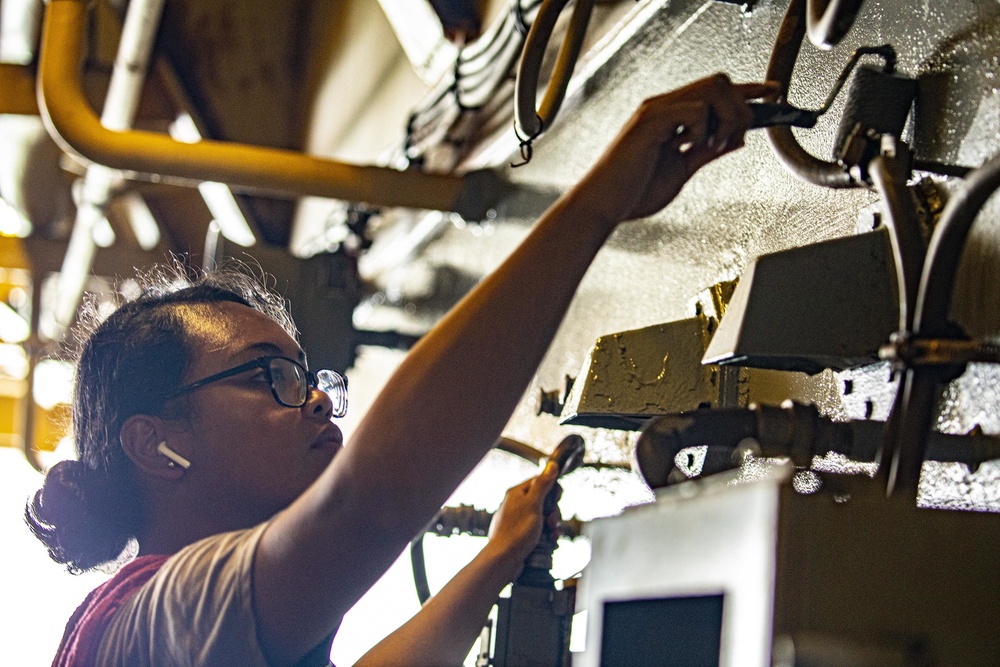 Sailors paint a bulkhead