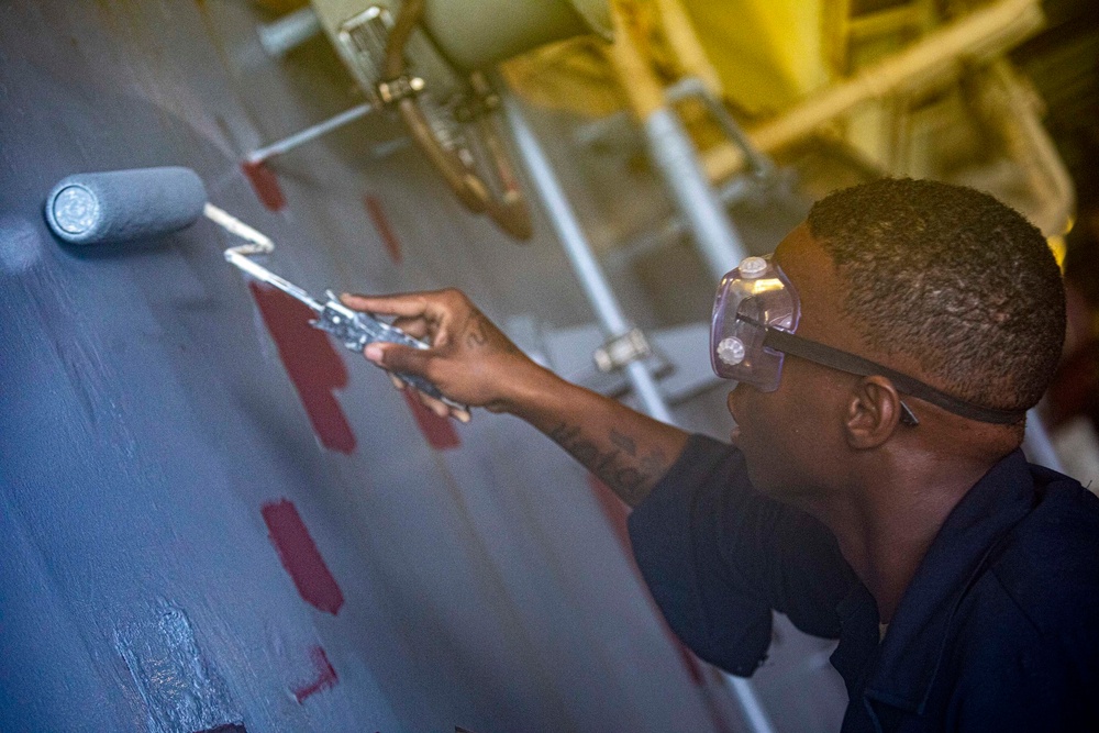 Sailors paint a bulkhead