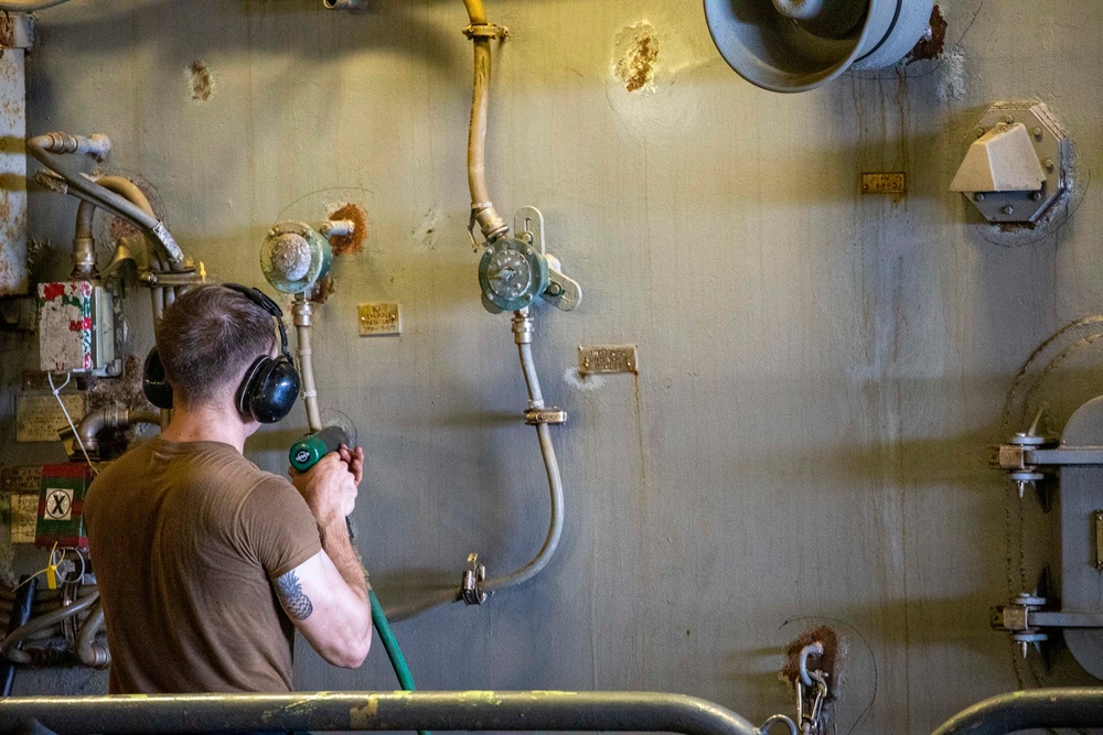 Sailors paint a bulkhead