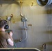 Sailors paint a bulkhead