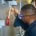 Sailors paint a bulkhead