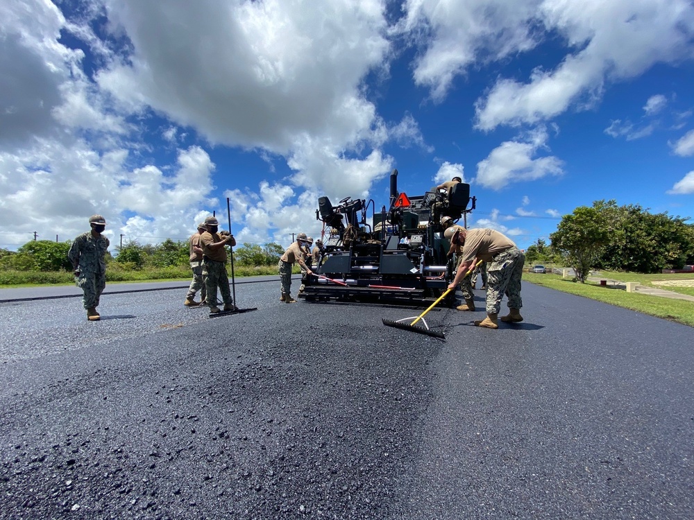 Seabees with NMCB-5’s Detail Guam lay asphalt in support of Naval Computer and Telecommunications Area Master Station, Pacific