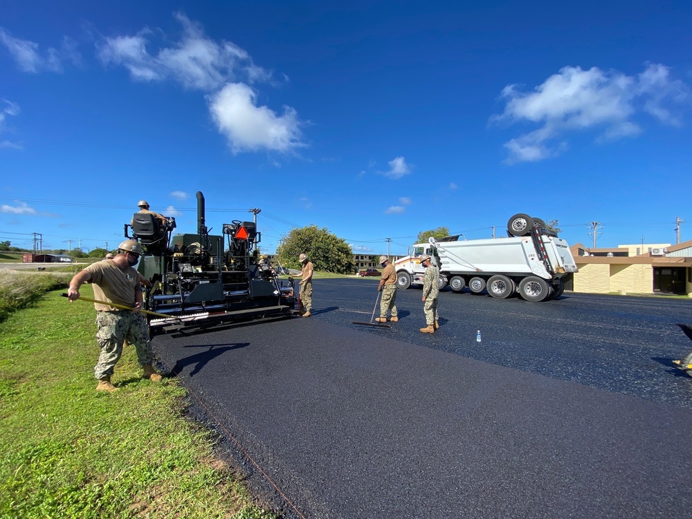 Seabees with NMCB-5’s Detail Guam lay asphalt in support of Naval Computer and Telecommunications Area Master Station, Pacific