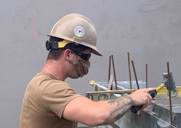 U.S. Navy Seabees with NMCB-5 build concrete masonry unit enclosures at Torii Housing onboard Marine Corps Air Station, Iwakuni
