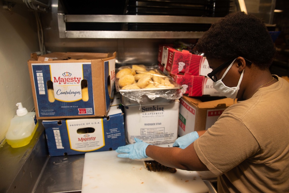 USS Princeton Sailors prepares food in the ship’s galley