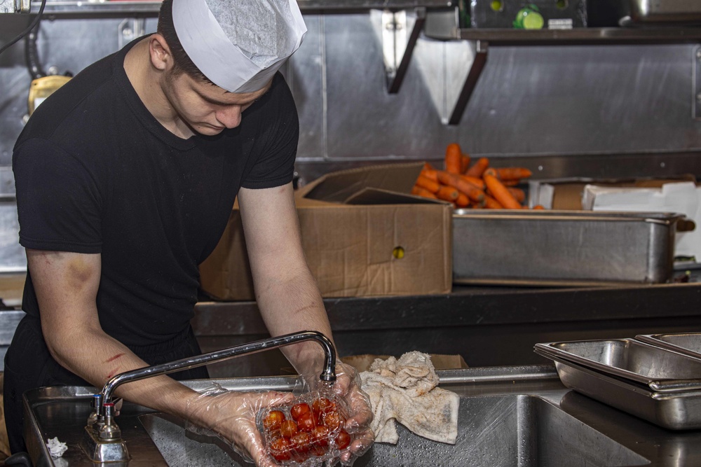 Sailors and Marines cook in the galley