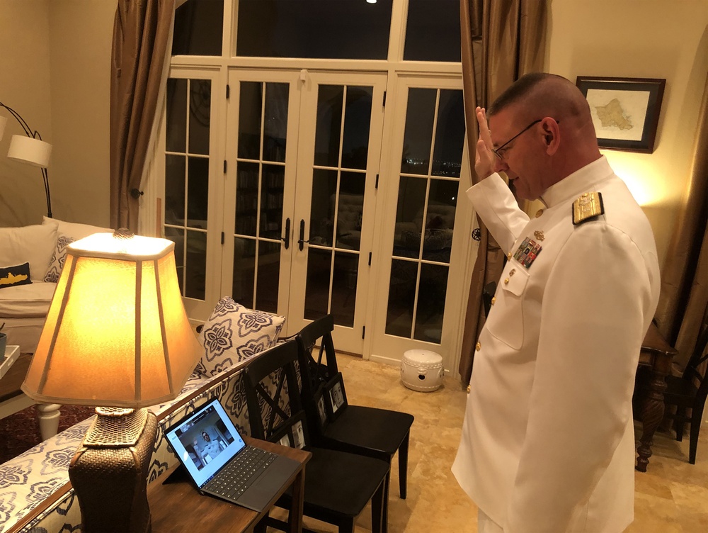 Rear Adm. Dave Welch administers the Oath of Office to his son, Midshipman Geoffrey P. Welch