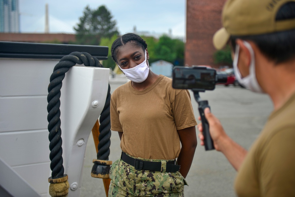 Aircrew Survival Equipmentman 2nd Class Kimberly Watson, assigned to USS Constitution, gives a Facebook live gun drill demonstration