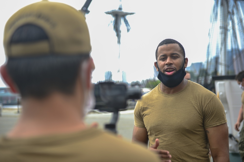 Retail Specialist 1st Class Kenneth Johnson, assigned to USS Constitution, gives a Facebook live gun drill demonstration