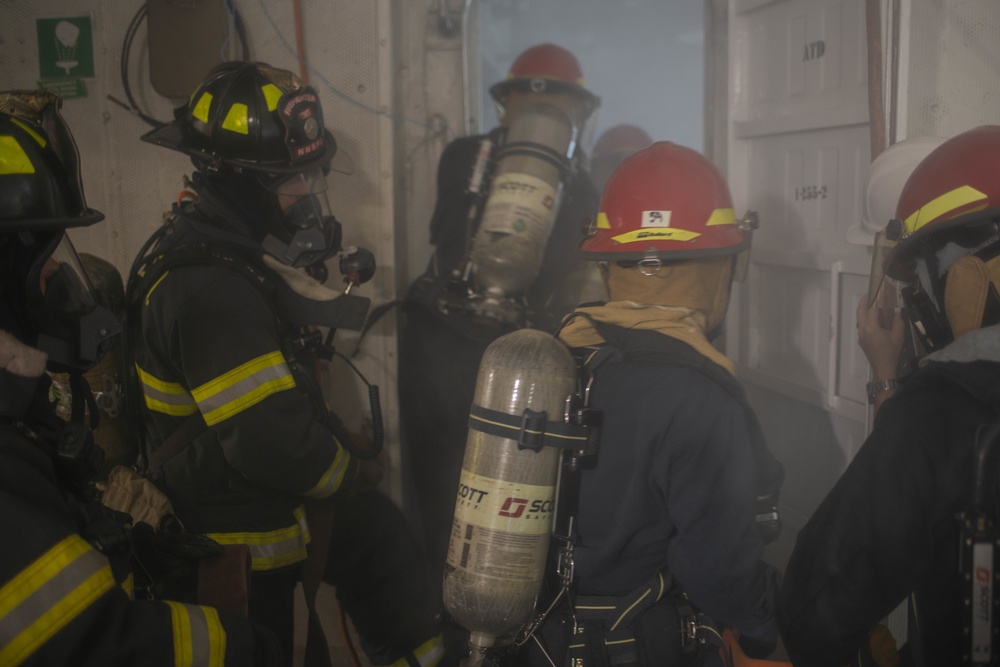 Sailors and Firefighters Train During a Drill
