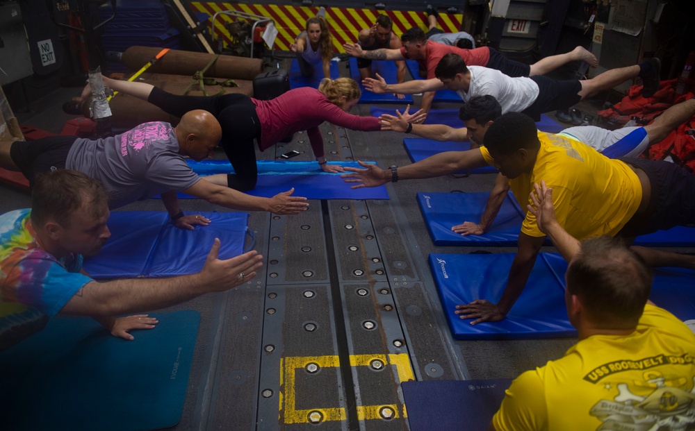 USS Roosevelt Sailors practice yoga