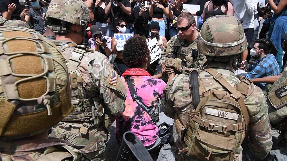 Cal Guard's 79th Infantry Brigade Combat Team Captain kneels with protesters in support